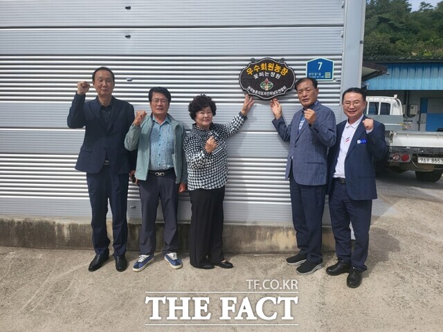 한국농촌지도자 영광군연합회가 우수농장에 현판을 달고 있다. /영광군