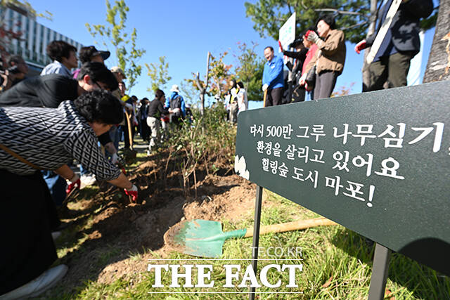 마포구민들이 '다시 500만 그룹 나무심기' 식재 행사에서 나무를 심고 있다.