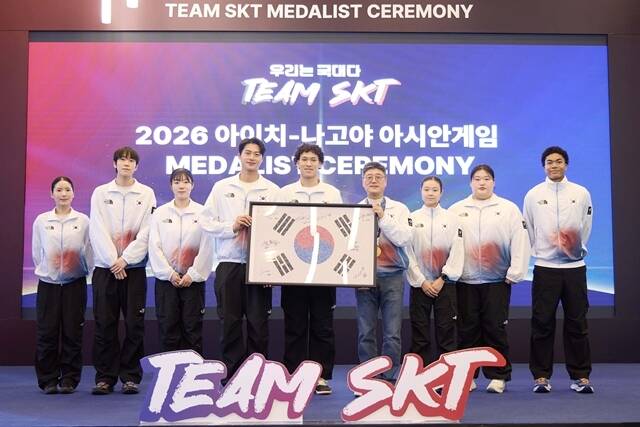 7일 서울 SKT타워에서 열린 '메달리스트 세리머니'에서 'Team SKT' 선수들이 사인을 담은 '국민응원 태극기' 액자를 정재헌 SK텔레콤 CEO에게 전달하고 있다. /SK텔레콤