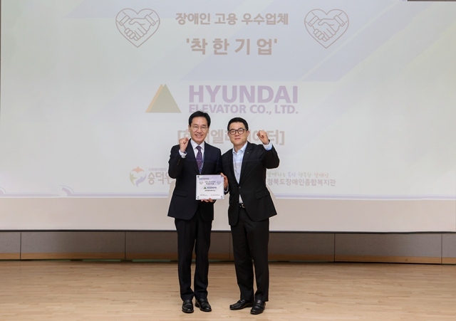 안지훈 현대엘리베이터 인사담당(오른쪽)과 이준호 사회복지법인 숭덕원 이사가 7일 충주 유네스코 국제무예센터에서 열린 '착한기업' 현판 수여식을 마친 뒤 기념 촬영을 하고 있다. /현대엘리베이터