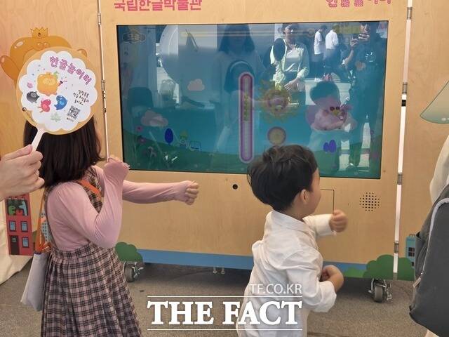 한글놀이터에서는 아이들 2명이 한글 자음과 모음을 몸으로 표현하는 놀이를 하고 있었다. 놀이터에 마련된 화면에 ㅕ가 나오자 아이들은 몸을 왼쪽으로 돌리고 허공에 두 손을 쭉 뻗었다. ㅛ가 나오자 두 손을 위로 올린 채 제자리에서 두세 번 뛰었다. ㅠ가 나오자 진행자가 ㅠ, 허리 숙이고 바닥에 주먹!이라고 외쳤고, 아이들은 양손 주먹을 바닥으로 내리쳤다. 한 남자아이는 뛸 때마다 까르르 웃었다. /안디모데 기자