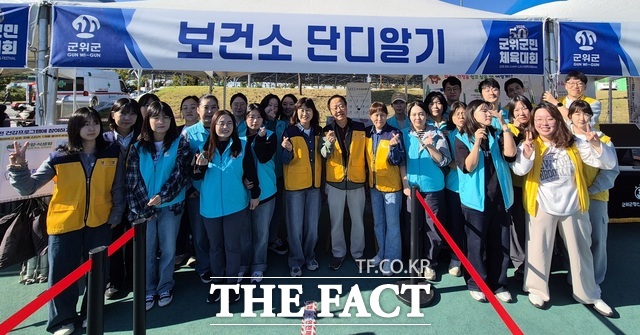 군위군보건소 직원들이 8일 군위종합운동장에서 열린 제50회 군위군민체육대회 건강홍보부스에서 기념 촬영을 하고 있다. 보건소는 이날 예방접종과 질병 예방, 건강한 생활습관을 안내하고 현장 의료지원을 병행했다. /군위군