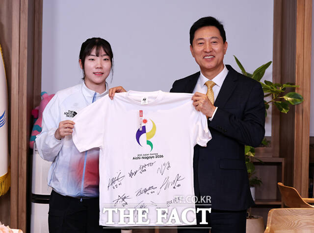 오세훈 서울시장(오른쪽)이 8일 서울 중구 서울시청 시장실에서 서울시청 소속 선수단 격려 오찬에 앞서 2026 아이치·나고야 아시안게임 펜싱 여자 사브르 단체전 금메달리스트 전하영(서울시청)과 선수단의 사인이 담긴 티셔츠를 들고 기념촬영하고 있다.