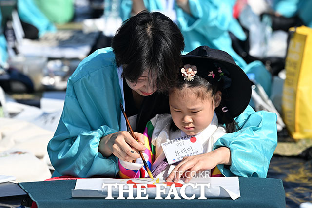 한글날 제정 100주년을 맞은 9일 오전 서울 종로구 광화문광장에서 열린 제17회 휘호대회에 참가한 한 어린이의 선글라스에 '열어가자 아름다운 바른한글'이 비치고 있다. /서예원 기자