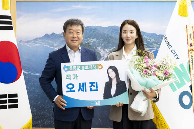 남한권 울릉군수(왼쪽)가 베스트셀러 작가이자 유튜버, 아웃도어 전문가인 오세진 씨를 홍보대사로 위촉한 후 기념사진을 찍고 있다. /울릉군