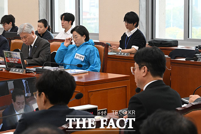 정혜경 진보당 의원이 13일 오전 서울 여의도 국회에서 열린 기후에너지환경노동위원회의 고용노동부에 대한 국정감사에서 반도체 하청업체 직원이 착용하는 방진복을 입고 참석해 김영훈 고용노동부 장관을 바라보고 있다. /국회=서예원 기자