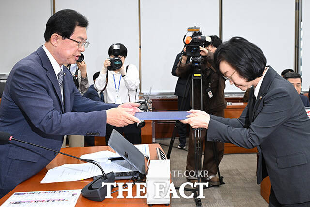 이만희 위원장에게 선서문 제출하는 오유경 식품의약품안전처장(오른쪽).