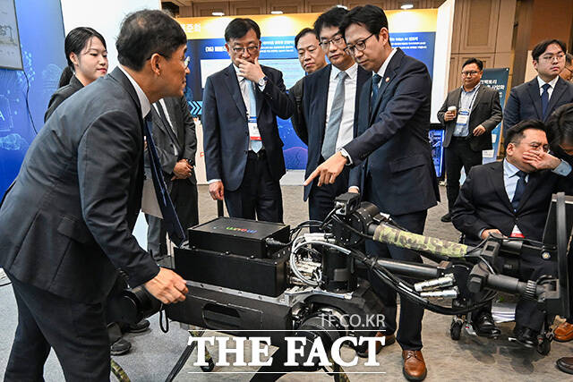 과학기술정보통신부가 주최하는 '피지컬 AI Tech Week'가 13일 오후 서울 강남구 코엑스에서 열린 가운데 배경훈 부총리 겸 과학기술정보통신부 장관(오른쪽)이 4족 로봇용 지뢰 탐지 임무 장비를 살펴보고 있다. /송호영 기자