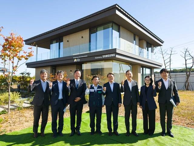 김성환 기후에너지환경부 장관(왼쪽 4번째부터), 박승희 삼성전자 CR 담당 사장, 김철기 삼성전자 DA 사업부장 부사장이 14일 경기도 화성시 '삼성 AI 모듈러 홈' 견본 주택 앞에서 기념 촬영을 하고 있다. /삼성전자