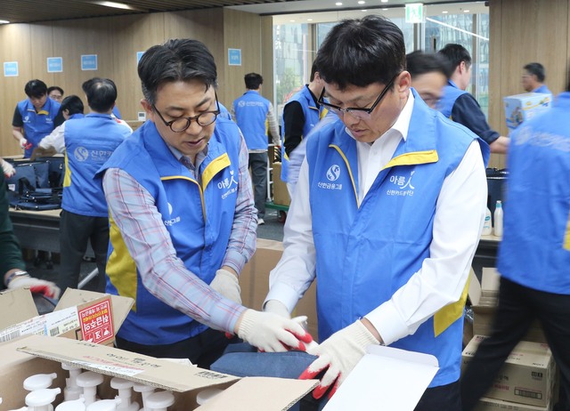 신한카드 본사에서 진행한 봉사활동에서 박창훈 신한카드 사장(오른쪽)과 임부서장 100여명이 장기입원 환아를 위한 항균·문구용품 키트 제작 및 포장을 하고 있다. /신한카드