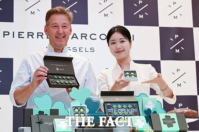 피에르 마르콜리니와 모델이 수능 응원 문구 피켓과 함께 포즈를 취하고 있다.