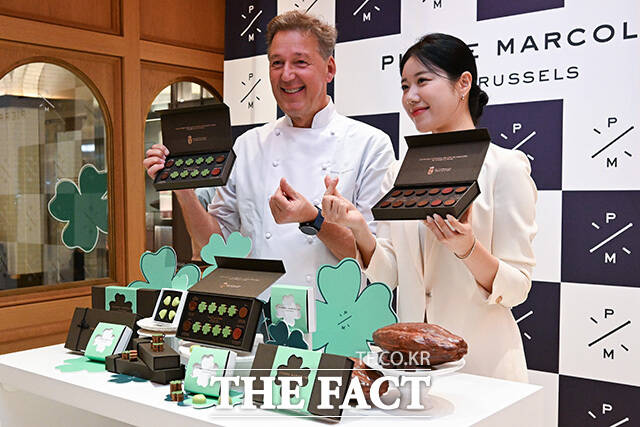 피에르 마르콜리니와 모델이 수능 응원 문구 피켓과 함께 포즈를 취하고 있다.