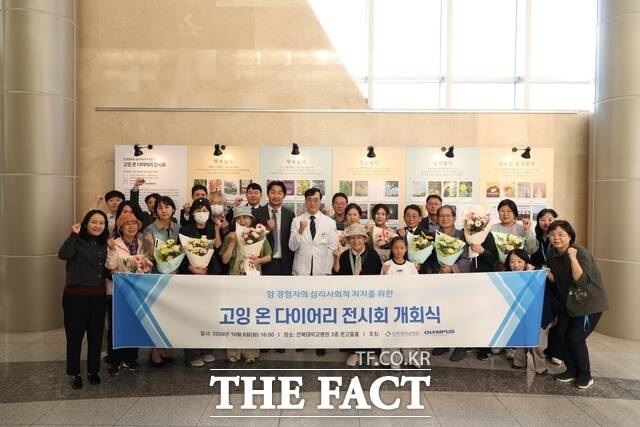 19일 전북대학교병원 어린이병원 앞 전시장에서 암 진단과 치료를 겪은 암 생존자들의 진솔한 일상과 마음을 담아낸 '고잉 온(Going-on) 다이어리' 전시회가 열린 가운데 참석자들이 기념 촬영을 하고 있다. /전북대병원