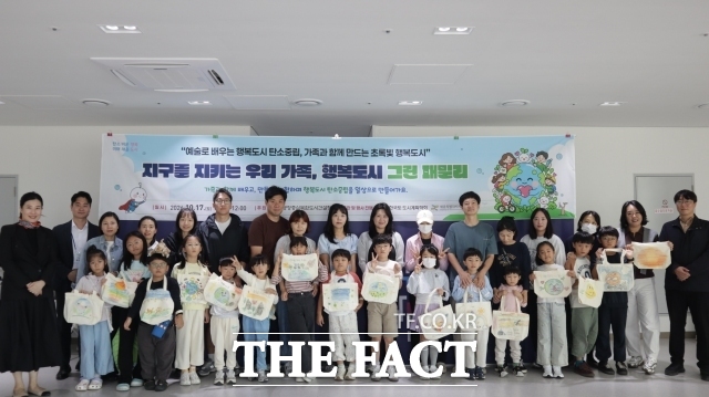 17일 행복청 국립박물관단지 통합운영지원센터에서 열린 '2026 미래세대·시민 참여 탄소중립 콘서트'에서 참가 가족들이 직접 만든 에코백을 들고 탄소중립 실천을 다짐하고 있다. /행복청