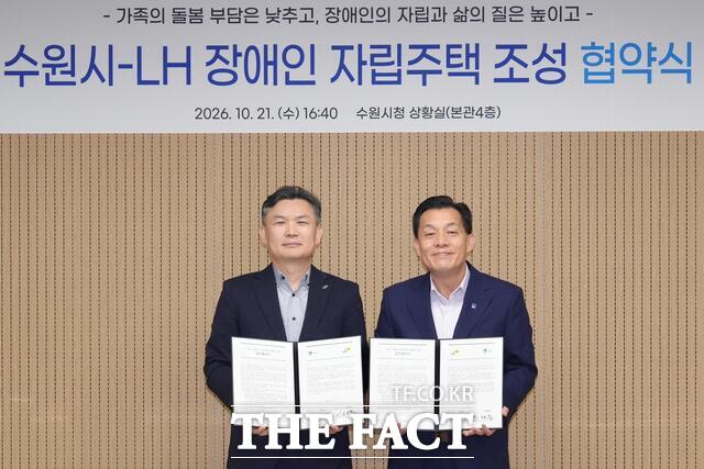 권운혁 한국토지주택공사(LH) 경기남부지역본부장(왼쪽)과 이재준 수원시장이 21일 수원시청에서 열린 장애인 자립주택 조성 업무협약식에서 협약서를 들고 기념 촬영을 하고 있다. /수원시