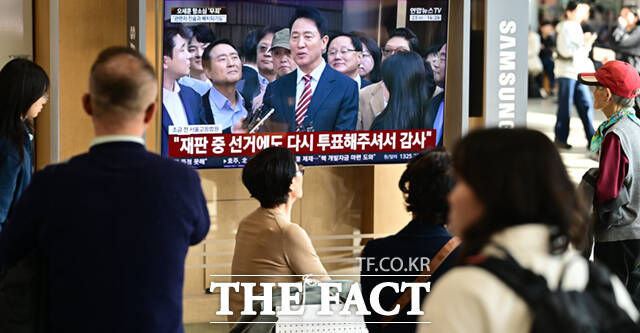 명태균 여론조사 대납 의혹을 받고 있는 오세훈 서울시장이 항소심에서 무죄를 선고 받은 가운데 23일 서울 용산구 서울역에서 시민들이 관련 뉴스를 시청하고 있다. /이새롬 기자