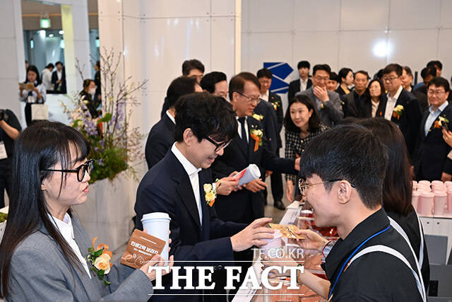 장항준 감독과 김은희 작가, 이환주 KB국민은행장이 참여 업체 관계자로부터 설명을 듣고 있다.