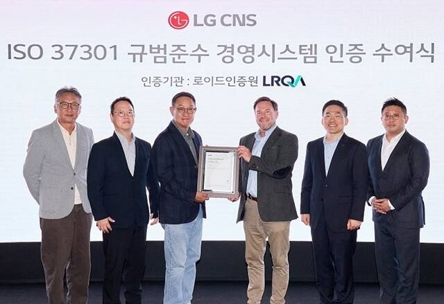 현신균 LG CNS 사장(왼쪽에서 3번째)과 스튜어트 켈리 로이드인증원 글로벌커머셜어드바이저(왼쪽에서 4번째)가 최근 진행된 준법경영 시스템 국제표준 인증 수여식에서 기념 촬영을 하고 있다. /LG CNS