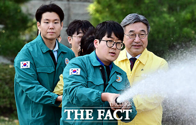윤호중 행정안전부 장관(가운데)이 27일 오후 서울 종로구 정부서울청사에서 열린 화재 대피 민방위 훈련에 참석해 투척용 소화기를 실습하고 있다. /임영무 기자