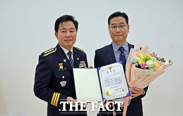 한국스포츠레저 길제용 실장(오른쪽)이 21일 제81주년 경찰의 날 기념행사에서 함경철 서울남대문경찰서장으로부터 감사장과 꽃다발을 받은 후 기념 촬영을 하고 있다./한국스포츠레저