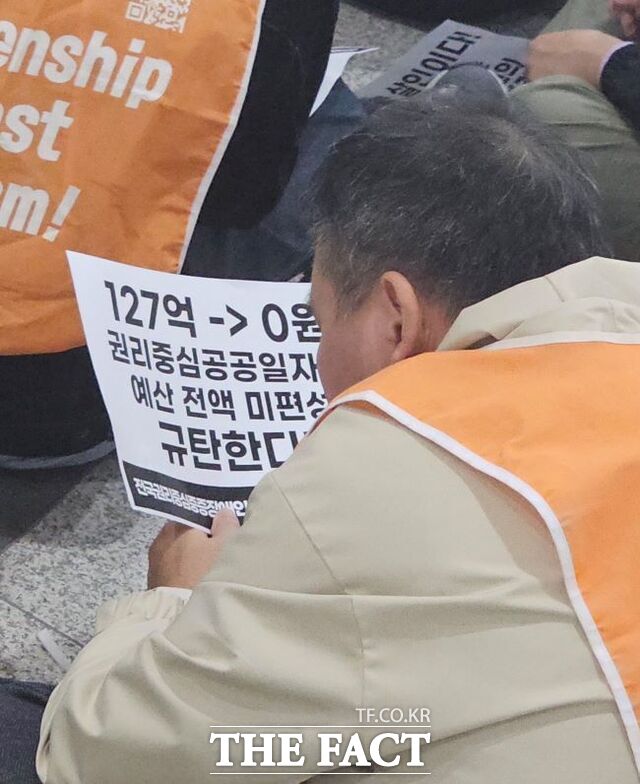 27일 오후 경기도청 1층 로비에서 전국권리중심중증장애인맞춤형공공일자리협회(전권협) 소속 한 시각장애인 노동자가 유인물을 힘들게 읽고 있다. /이승호 기자