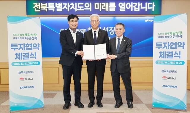 김인욱 ㈜두산 전자BG장(가운데)이 27일 전북특별자치도청에서 열린 광모듈용 CCL 전용 생산 라인 구축 투자 협약식에서 이원택 전북특별자치도지사(왼쪽), 정성주 김제시장과 기념사진을 촬영하고 있다. /두산