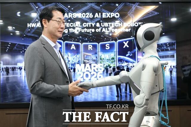 정명근 화성시장이 'MARS 2026' 개막식 오프닝 무대에서 발레 퍼포먼스를 선보일 로봇 '루나(LUNA)'와 악수를 하고 있다. /화성시