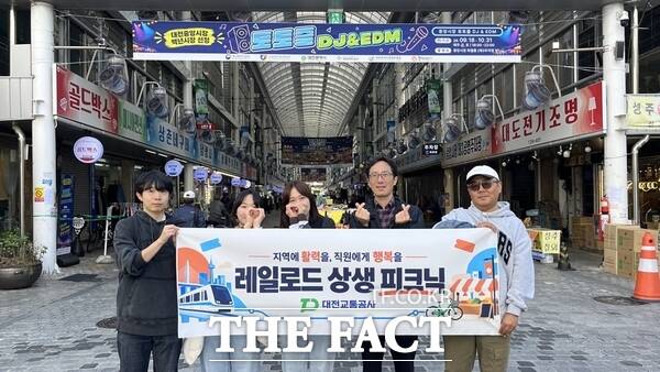 대전교통공사는 오는 12월까지 2개월간 지역 경제 활성화와 소속 직원의 일·가정 양립을 지원하기 위해 역세권과 원도심 투어를 지원하는 '레일로드 상생 피크닉'을 운영한다. 사진은 대전중앙시장에서 '레일로드 상생 피크닉' 행사를 진행하고 있는 대전교통공사 직원들. /대전교통공사