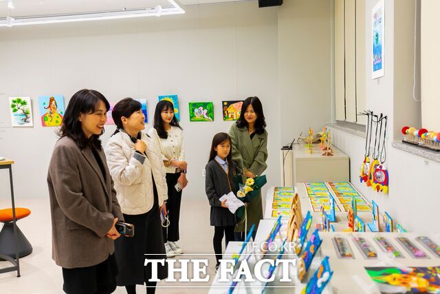 '대전시 인권공모전' 포스터 부문에서 우수상을 받은 정지율 학생과 학부모(왼쪽에서 두번째)가 대학 관계자들과 작품 전시실을 둘러보고 있다. /건양사이버대