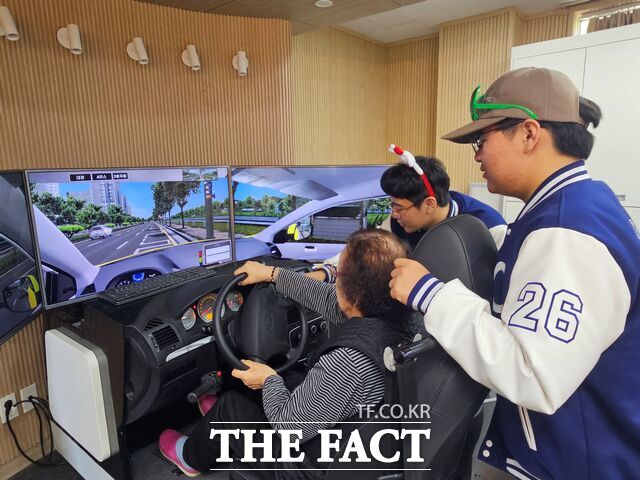 충남도립대학교 작업치료학과 학생들이 지역의 한 어르신에게 인지·신체 기능 유지를 돕는 운전 시뮬레이션 재활 프로그램을 진행하고 있다. /충남도립대