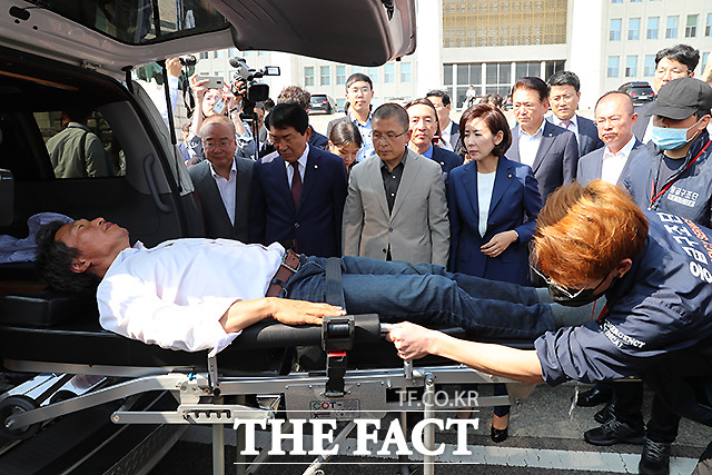 병원으로 이송되는 이 의원과 이를 지켜보는 동료 의원들. /뉴시스