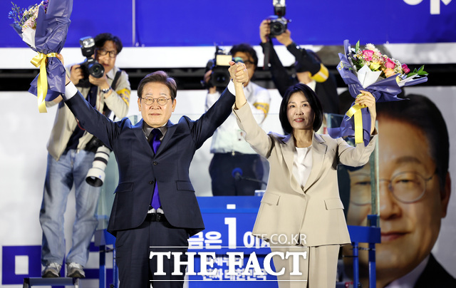 이재명 더불어민주당 대선 후보와 김혜경 여사가 4일 오전 서울 여의도 국회 앞에서 열린 국민 개표방송 행사에서 꽃다발을 받은 뒤 시민들을 향해 인사하고 있다. /뉴시스