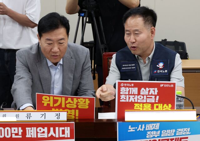 10일 정부세종청사에서 열린 최저임금위원회 4차 전원회의에 앞서 류기정 사용자 위원과 정문주 근로자 위원이 각자의 주장이 담긴 팻말을 자리에 배치하고 있다. / 뉴시스