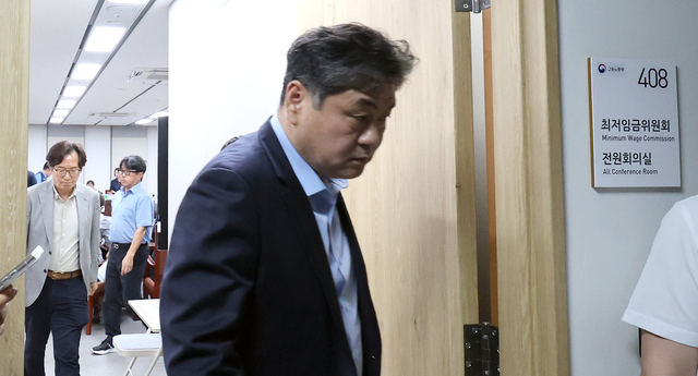 이인재 최저임금위원회 위원장이 9일 세종시 정부세종청사에서 열린 11차 전원회의에서 정회를 선언한 뒤 회의실을 나오고 있다. / 뉴시스