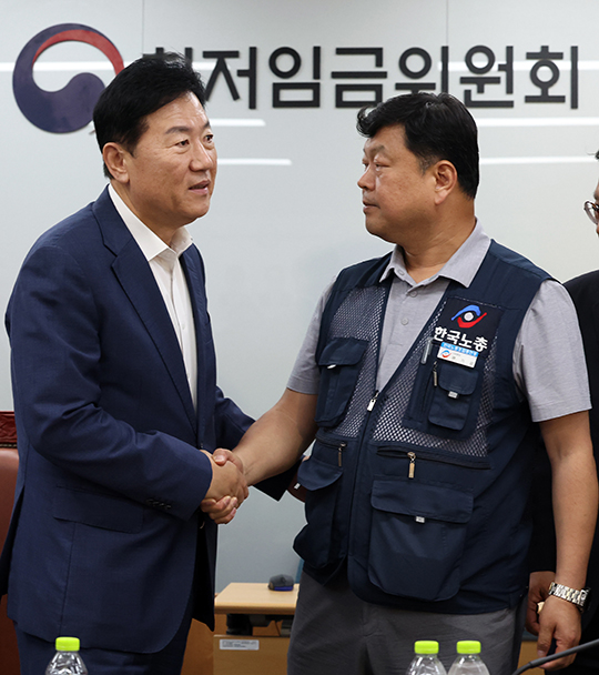 10일 밤 세종시 정부세종청사에서 열린 최저임금위원회 전원회의에서 2026년도 적용 최저임금이 1만 320원으로 결정됐다. 회의가 끝난 후 류기정 사용자 위원과 류기섭 근로자 위원이 악수하고 있다. 이날 민주노총은 공익위원이 제시한 심의촉진구간에 반발, 집단 퇴장했다./뉴시스