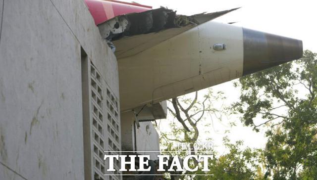 지난달 12일(현지시간) 인도 구자라트주 아마다바드에서 발생한 여객기 추락 사고 현장 건물 외벽에 기체 잔해가 튀어나와 있다. /AP.뉴시스