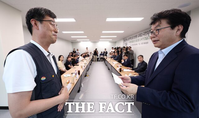 이한주(오른쪽) 국정기획위원장이 18일 서울 종로구 정부서울청사 창성동 별관 중회의실에서 열린 지난 정부 노동정책 희생 유족 간담회에서 김정욱 금속노조 쌍용자동차지부 법규실장으로부터 이재명 대통령에게 보내는 편지를 전달 받고 있다. /뉴시스