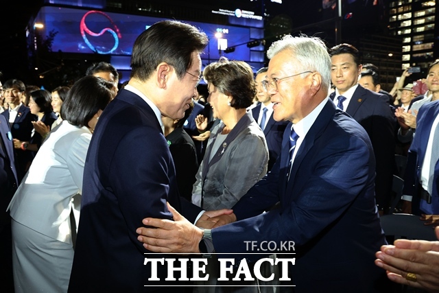 이재명 대통령이 15일 서울 광화문광장에서 열린 국민임명식 광복 80년, 국민주권으로 미래를 세우다 행사에서 문재인 전 대통령과 인사하고 있다. /뉴시스