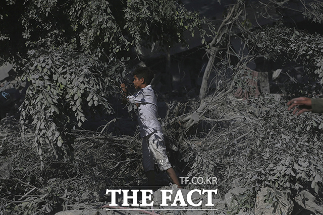 한 팔레스타인 소년이 공습을 받은 건물 잔해를 살펴보고 있다. /가자시티=AP.뉴시스