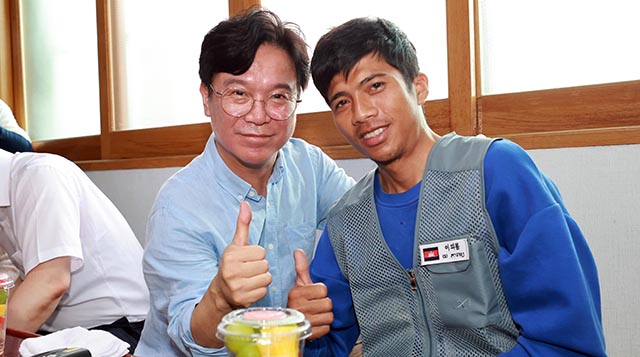 김영훈 고용노동부 장관이 지난 8월 전북 완주군의 외국인 고용 농가를 방문해 외국인 노동자와 기념촬영을 하고 있다./뉴시스