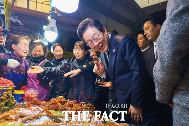 이재명 대통령이 23일 부산 부산진구 부전시장을 찾아 상인들과 이야기를 나누고 있다. /뉴시스