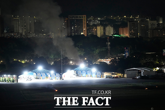 베네수엘라 수도 카라카스에서 3일(현지 시간) 오전 2시께 최소 7차례의 폭발음과 항공기 저공비행 소리가 들렸다고 AP통신이 보도했다. 베네수엘라 수도 카라카스에서 폭발음과 항공기 저공비행 소리가 들린 가운데 라칼로타 공항에서 연기가 피어오르고 있다. /카라카스=AP.뉴시스