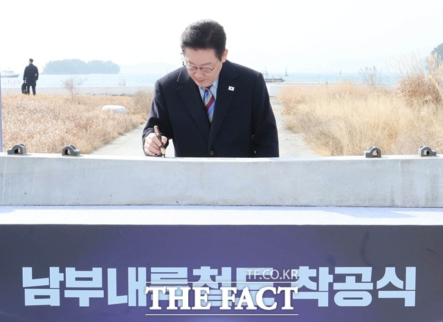 이재명 대통령이 6일 경남 거제시 견내량 인근에서 열린 남부내륙철도 착공식에서 침목에 서명을 하고 있다. /뉴시스
