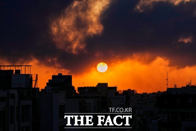 3일(현지시간) 이란 테헤란에서 미국과 이스라엘의 군사 공격 이후 치솟는 연기 뒤로 해가 지고 있다. /AP·뉴시스