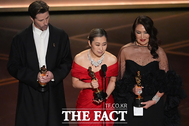 매기 강(가운데) 감독이 15일(현지 시간) 미 캘리포니아주 로스앤젤레스 돌비 극장에서 열린 제98회 아카데미 시상식에서 케이팝 데몬 헌터스(케데헌)로 장편 애니메이션상을 받은 후 소감을 말하고 있다. 왼쪽은 크리스 아펠한스 공동 연출자, 오른쪽은 L.M.웡 프로듀서 /로스앤젤레스=AP.뉴시스