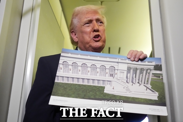 도널드 트럼프 미국 대통령이 지난달 29일(현지시간) 플로리다주 웨스트 팜 비치에서 메릴랜드주 앤드류스 기지로 향하는 에어포스원에서 연설하며 백악관의 새로운 이스트 윙 설계도를 들어 보이고 있다. /AP·뉴시스