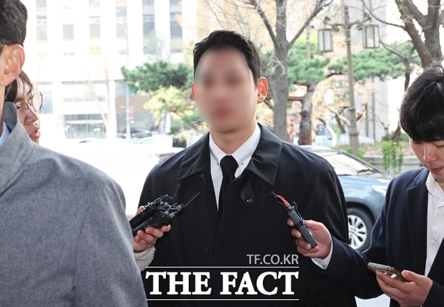 김병기 무소속 의원의 차남 김모씨가 2일 서울 마포구 서울경찰청 공공범죄수사대에 출석하며 취재진의 질문을 듣고 있다. /뉴시스