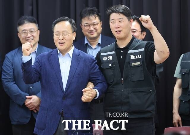 여명구 삼성전자 DS부문 피플팀장(왼쪽)과 최승호 초기업노조삼성전자지부 위원장이 지난 20일 경기도 수원시 장안구 경기고용노동청에서 열린 삼성전자 임금·성과급 협상을 마친 후 잠정합의안에 서명하며 파이팅을 외치고 있다. /뉴시스