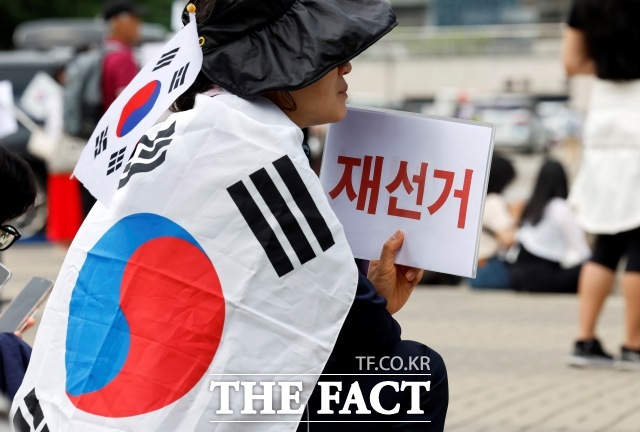 6·3 지방선거 투표용지 부족 사태를 규탄하며 재선거를 요구하는 '잠실 개표소 봉쇄 시위'가 계속되고 있는 가운데 법조계에서는 재선거가 사실상 불가능하다고 내다본다. 제9회 전국동시지방선거 투표용지 부족 사태에 항의하며 개표소 봉쇄 시위를 이어가는 시민들이 8일 서울 송파구 올림픽공원 핸드볼경기장에 설치된 개표소 앞에서 재선거를 요구하고 있다./뉴시스