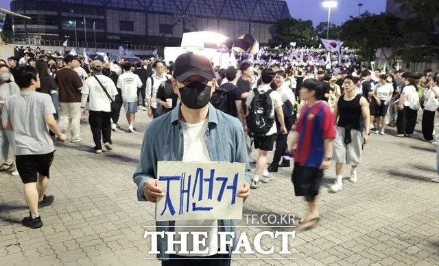 장동혁 국민의힘 대표가 지난 6일 서울 송파구 올림픽공원 핸드볼경기장에 설치된 개표소 앞에서 투표용지 부족 사태에 항의하며 재선거를 요구하는 손피켓을 든 모습. /뉴시스